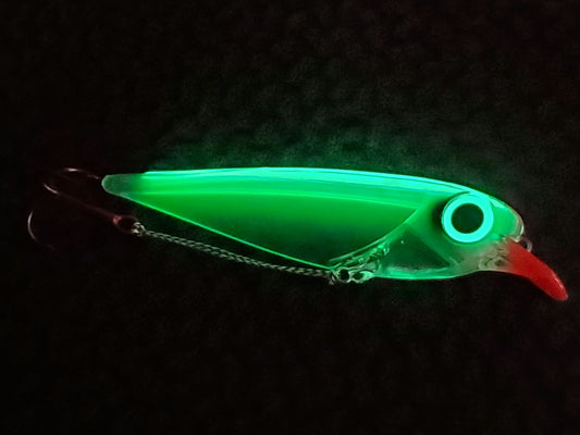 Glowing green Flatfin trolling lure on a dark background the body illuminated due to its transperency