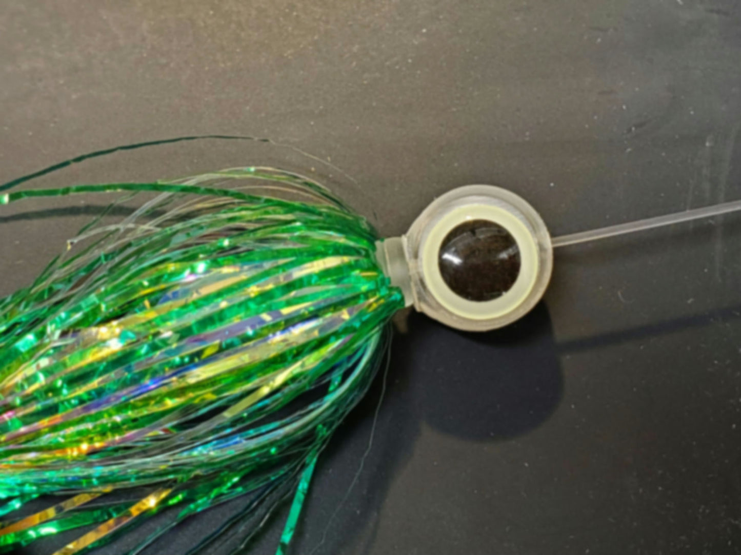 Fisher Tackle BigEye Trolling Fly BEAD shown rigged with a green crinkle mylar salmon trolling fly giving the fly a realistic strike triggering look. against black background