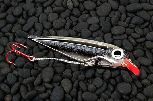 Black Racer trolling lure on wet stones background