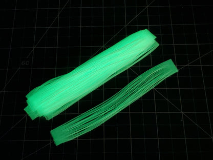 10pcs of superglow green Silicone Fly Skirts glowing brightly on workpad.