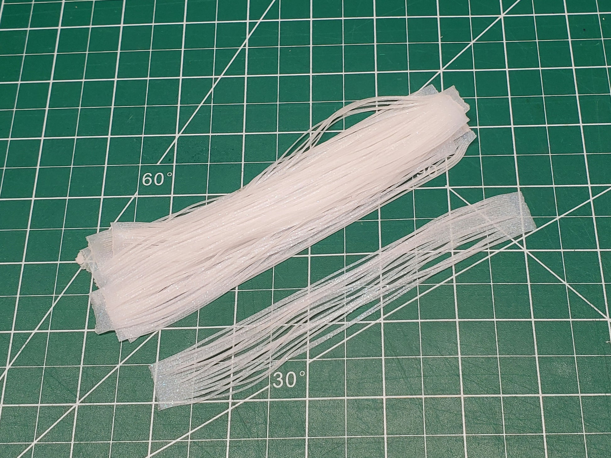 10pcs of Blue glow silicone skirt tabs on work mat in daylight ready to tie on salmon flies
