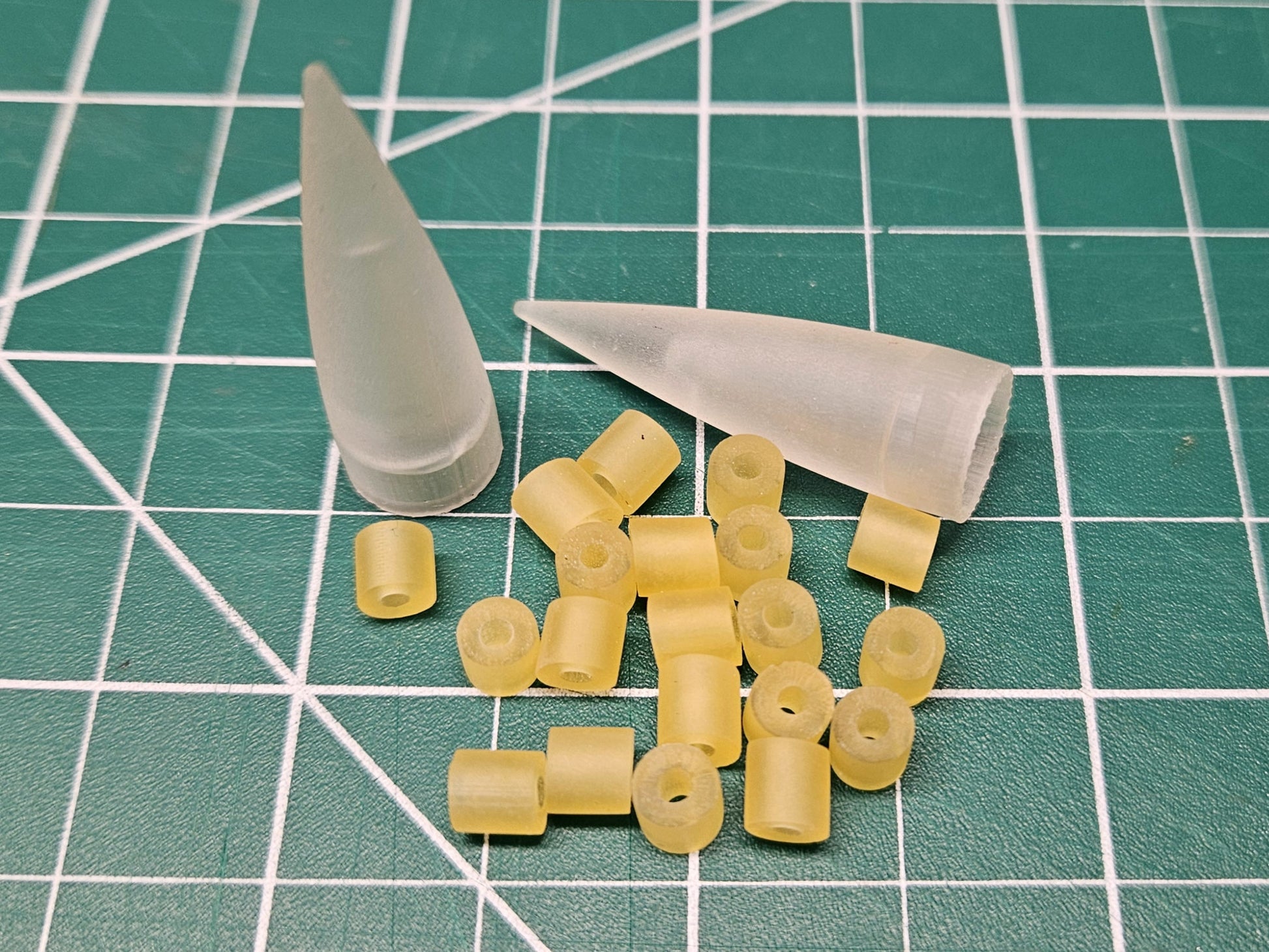 Assembly Cone Kit for Salmon Trolling Fly Heads showing 2 cones and 20 collars on green mat