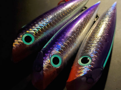 Three holographic trolling plugs with reflective surfaces and glowing eyes on a dark background.
