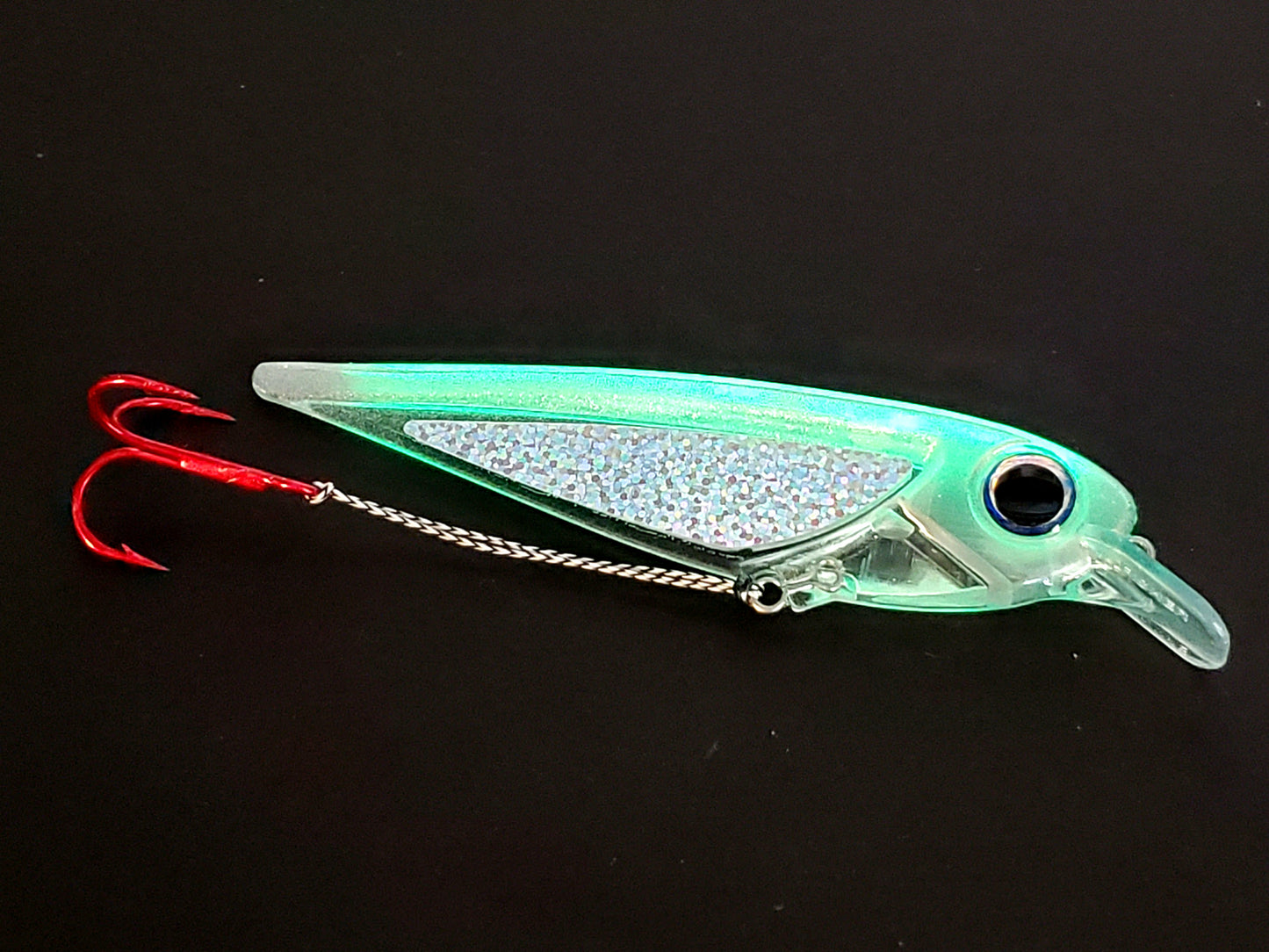 FlatFin 'FlashBang' trolling minnow glowing translucent with holographic sides and large realistic pearl blue eye on black background