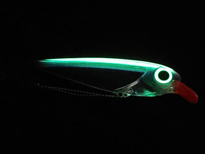 Purple FlatFin Minnow Lure on Black Pebble Background glowing in dark