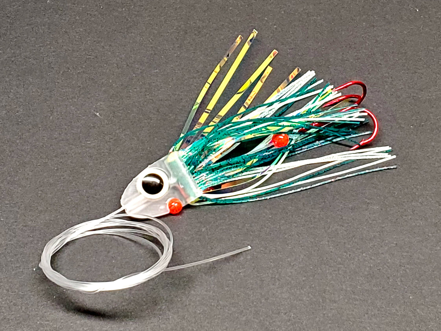 Salmon trolling fly with green skirting and large glow eye on a gray background