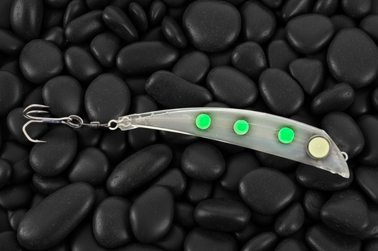 BubbleDart Long Living Dead Frog on black pebbles.  Green frog spots on transparent lure body with huge all glow eyes