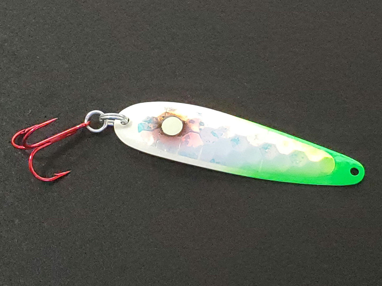 salmon spoon with a green and silver body on a dark background