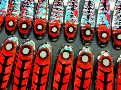 Red and black ladder back trolling spoons with glow dot-like 'eyes' arranged in rows.
