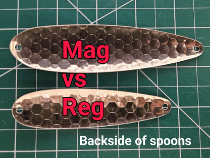 a Magnum vs a regular fisher tackle salmon spoon comparison against a green mat