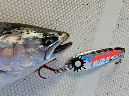 red salmon trolling spoon with salmon laying on deck of boat