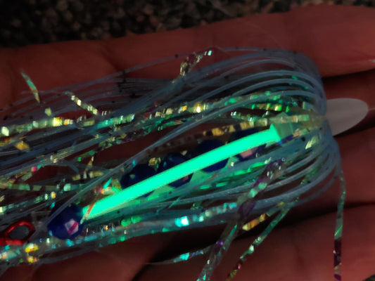 salmon trolling fly with glowing strip in low light palm of hand