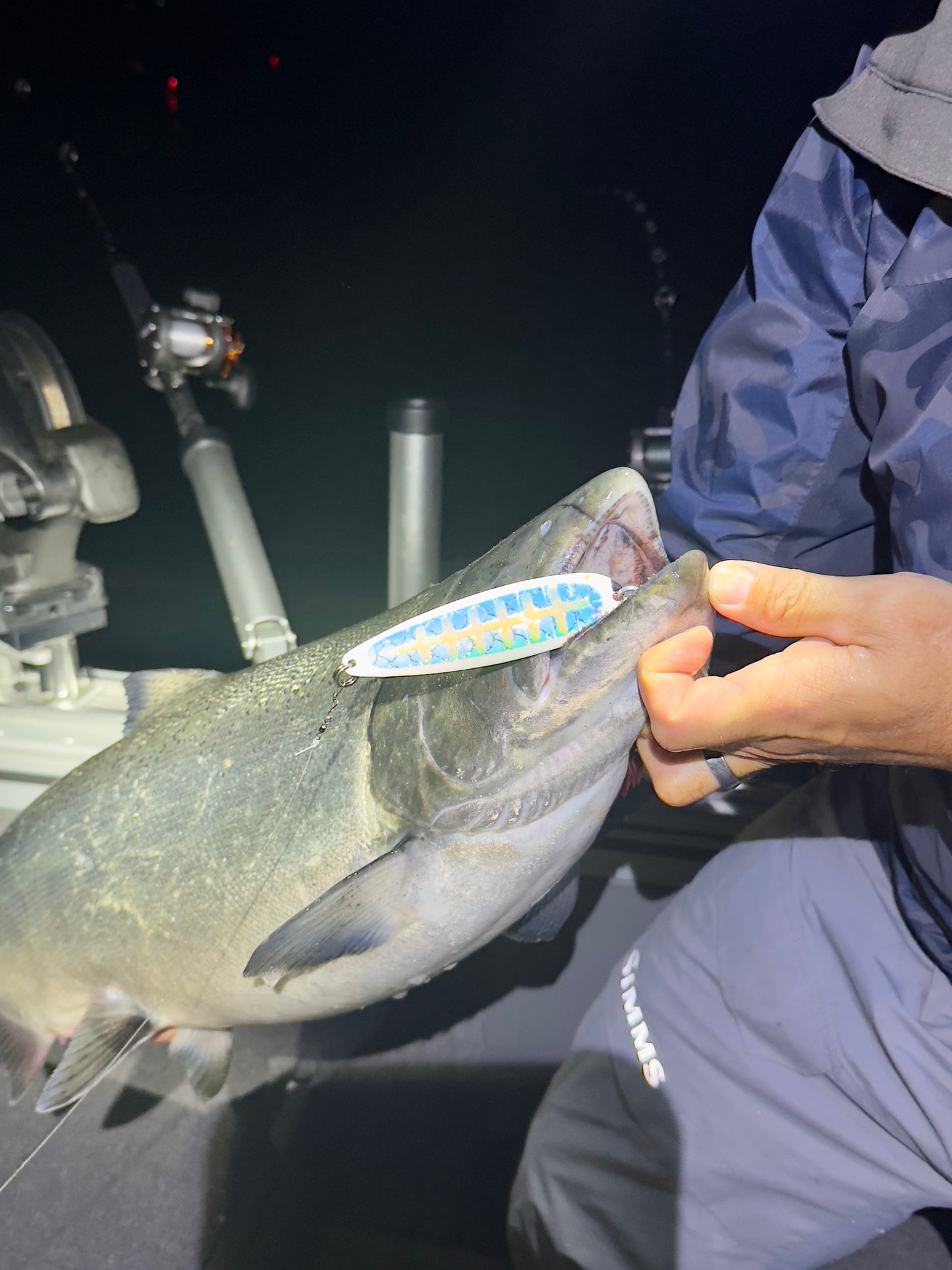 Mature King Salmon with Limetree salmon spoon hanging from jaw in boat at dark