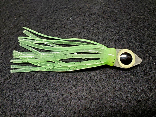 Green squid fishing lure with a black eye on a dark background