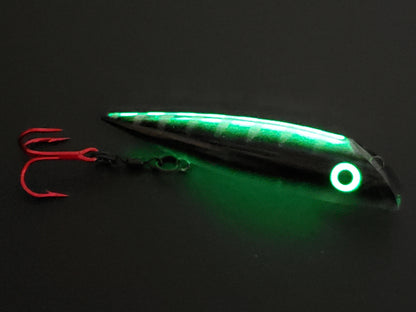 FishGunn Salmon Plug 'Black Racer' by Fisher Tackle in dark showing just spine, eyes and belly glowing...black body sides are blocking glow
