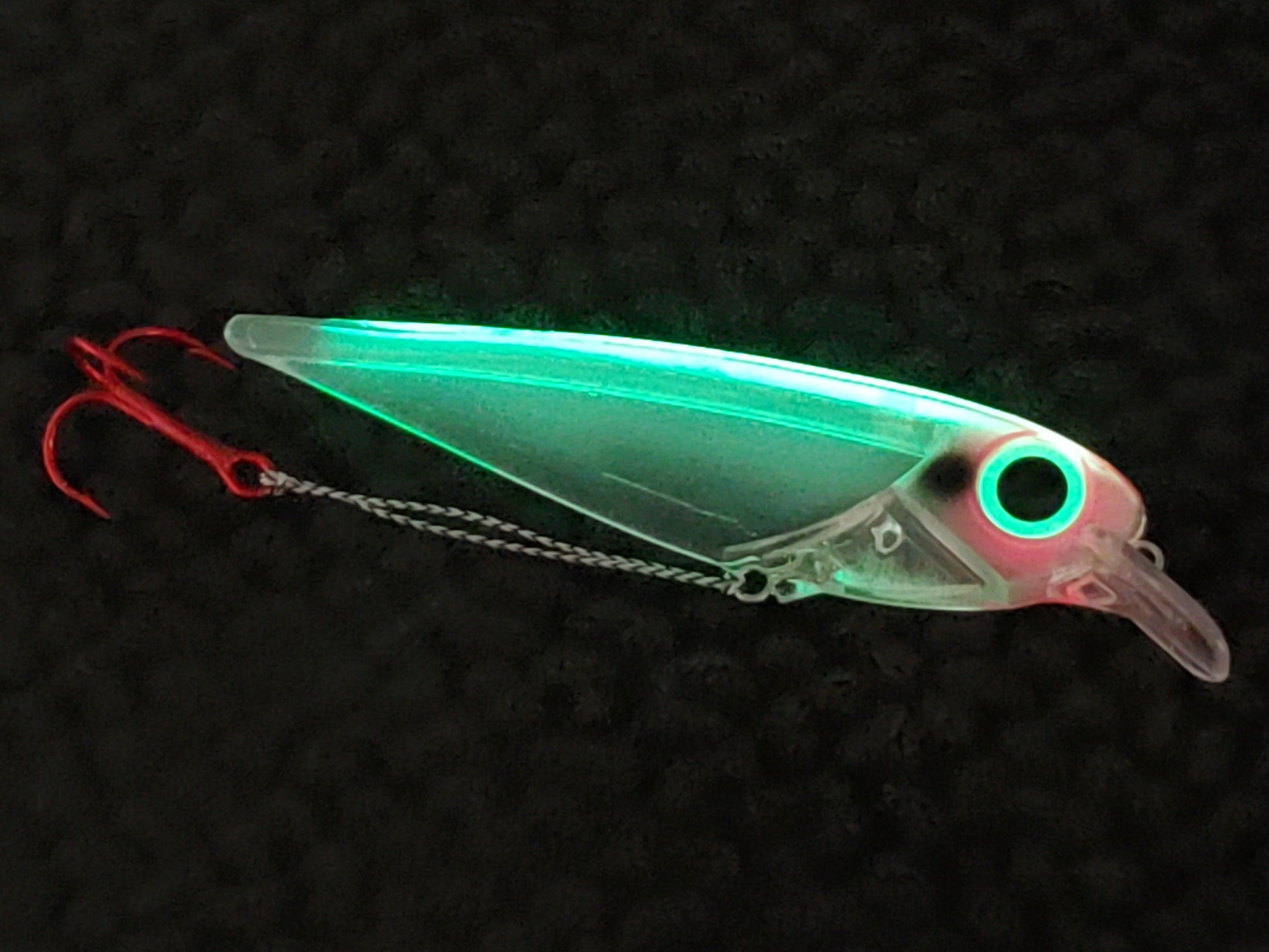 Trolling lure FlatFin Minnow 'Ether Bunny' by Fisher Tackle Company showing how well the body transmits the light from the glowing spine throughout and a large glow eye