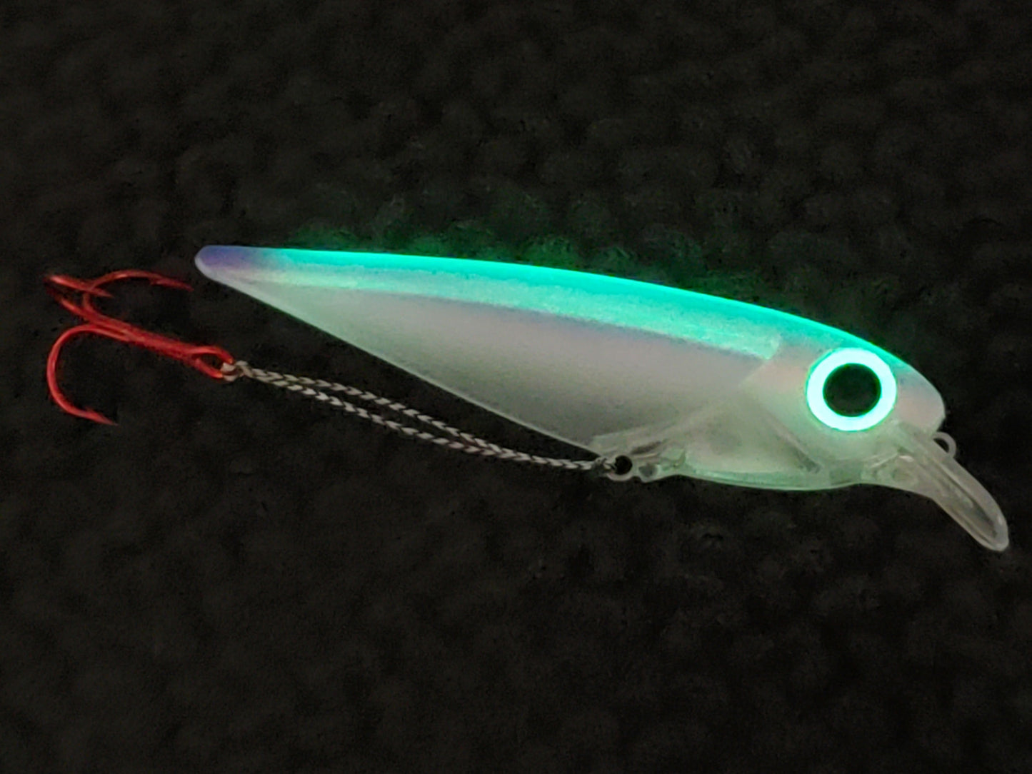 Fisher Tackle Company- FlatFin Minnow 'Venus' - blue/pink/purple trolling lure glowing in the dark, highlighting the oversized green glow eye and internal spine
