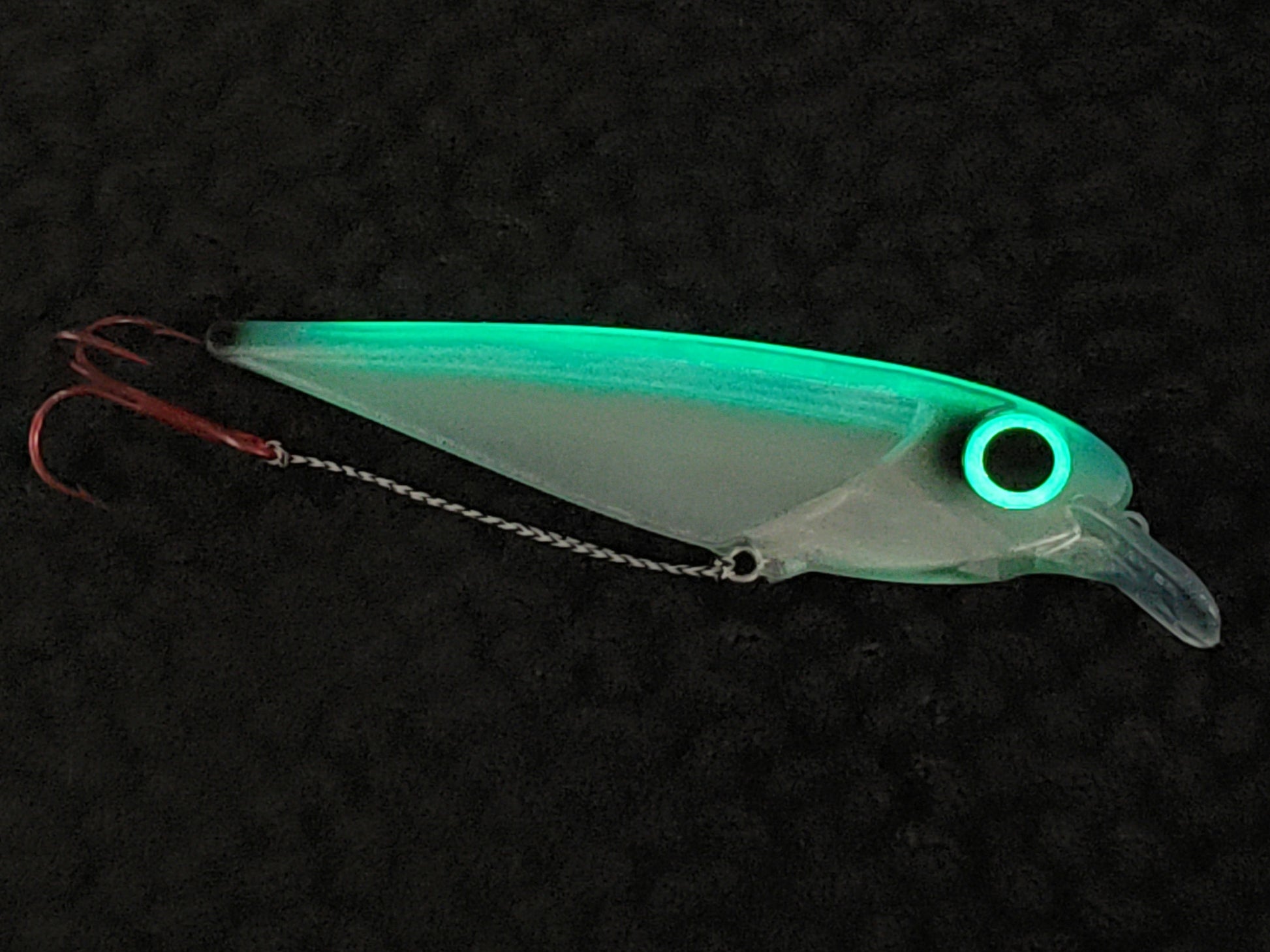 Fisher Tackle FlatFin Minnow 'Real Deal Blue' shown with unique spine and eye glowing in dark illuminating the translucent lure body