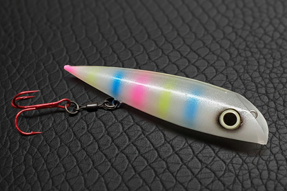 FishGunn Salmon Plug 'Tiger Bread' in daylight against black scaled leather background showing lures pearlescent white glitter sides,with hot pink,blue,yellow 'tiger' stripes -same colors as Wonderbread packaging