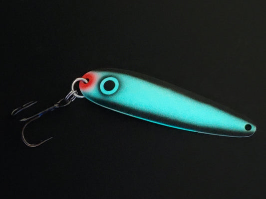 Fisher Tackle UltraMega Glow 'Black Gunnship' salmon trolling spoon with teal glow base, a large black eye and black sides glowing in dark